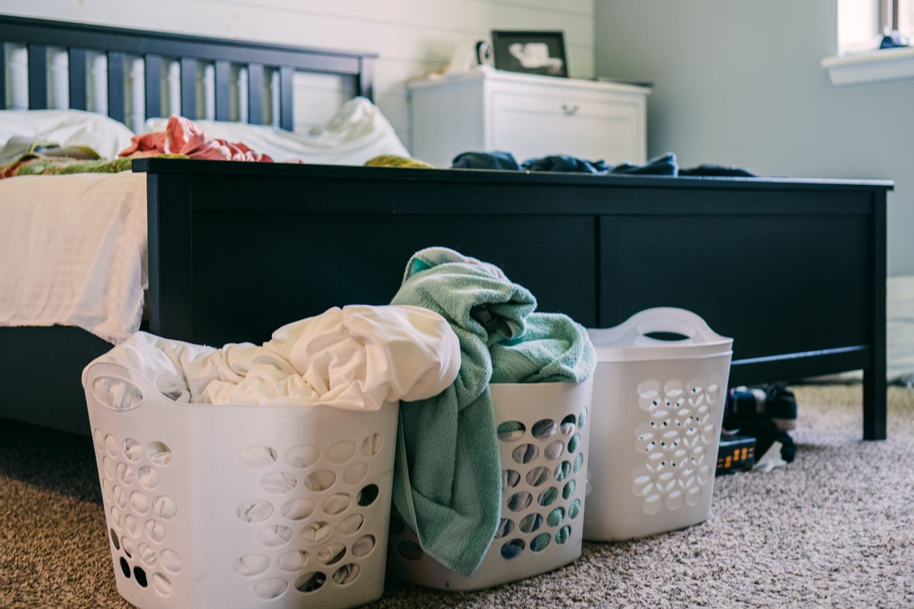 Crafting Captivating Headlines: Your awesome post title goes here A cozy bedroom scene featuring laundry baskets filled with clothing, placed on a carpeted floor.
